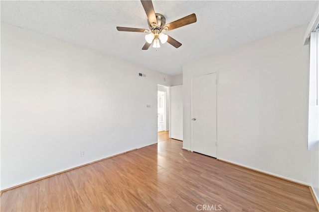 unfurnished room with light wood-type flooring, ceiling fan, and a textured ceiling