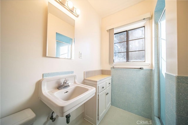 bathroom featuring tile walls and sink