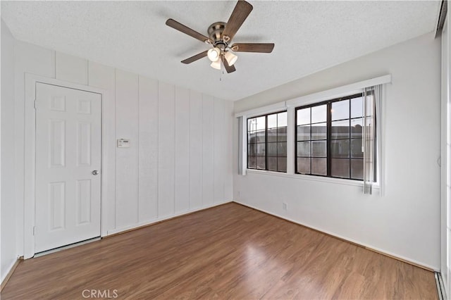 spare room with ceiling fan, a textured ceiling, and hardwood / wood-style floors