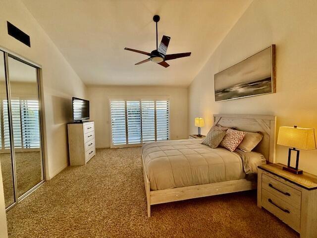 bedroom featuring ceiling fan, lofted ceiling, and dark colored carpet