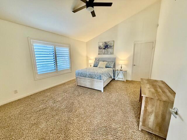 carpeted bedroom featuring vaulted ceiling and ceiling fan