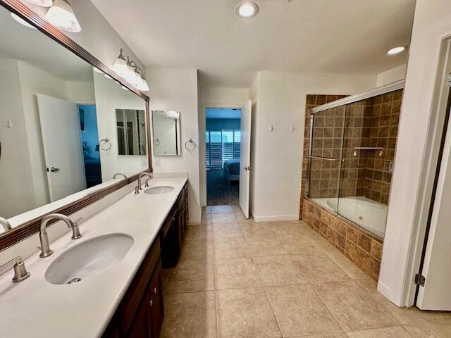 bathroom with tile patterned floors, vanity, and shower / bath combination with glass door