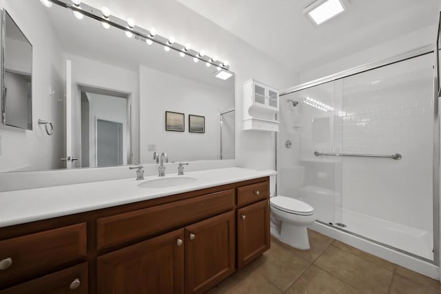 bathroom with toilet, vanity, tile patterned flooring, and walk in shower