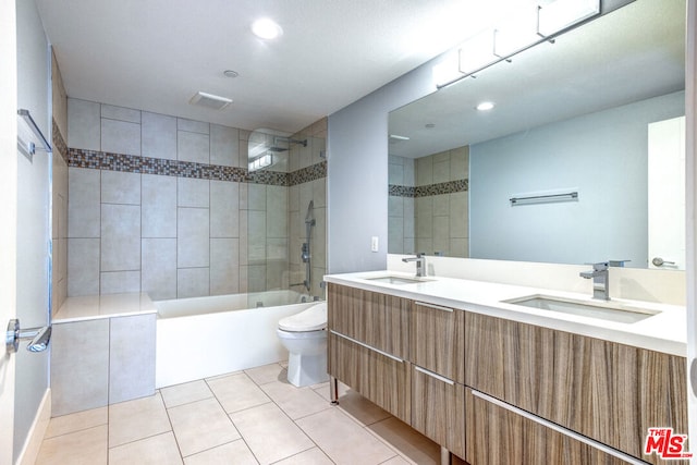 full bathroom featuring tile patterned floors, vanity, tiled shower / bath combo, and toilet