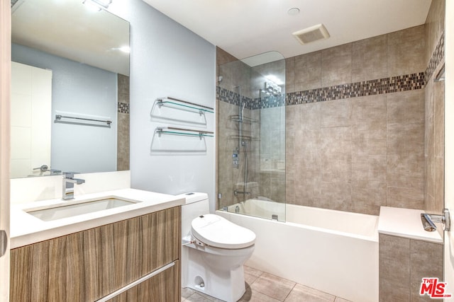 full bathroom with toilet, tile patterned flooring, vanity, and tiled shower / bath