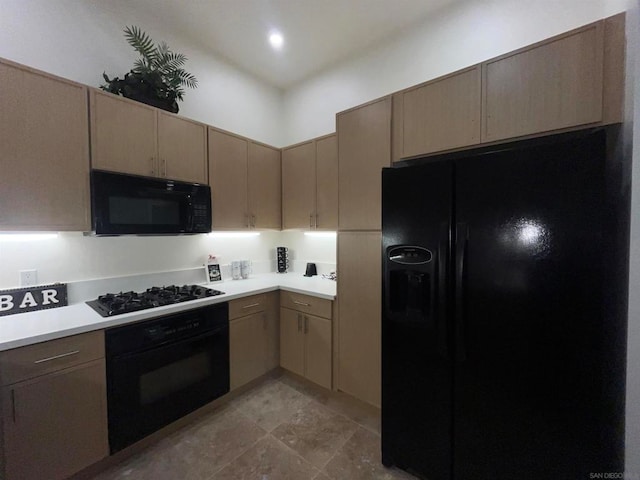 kitchen with light brown cabinets and black appliances