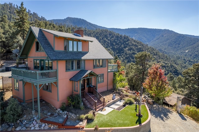 back of house featuring a balcony and a mountain view