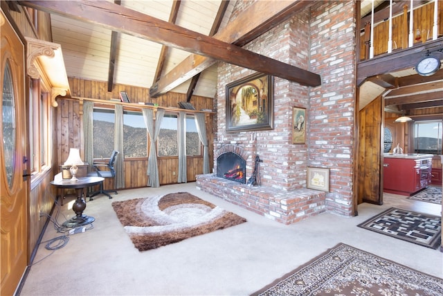 living room with lofted ceiling with beams, wooden walls, light carpet, and a fireplace