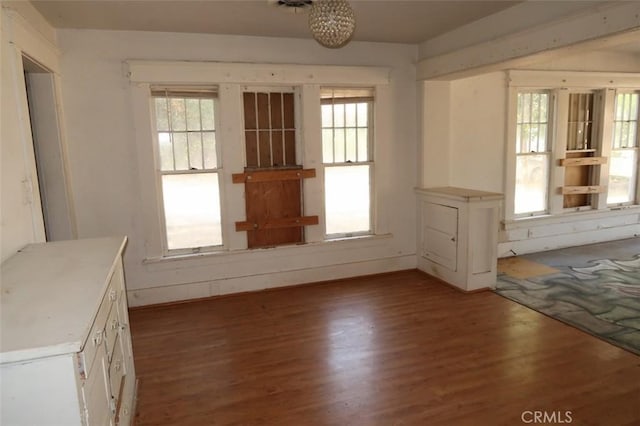 unfurnished dining area featuring a wealth of natural light and dark hardwood / wood-style flooring