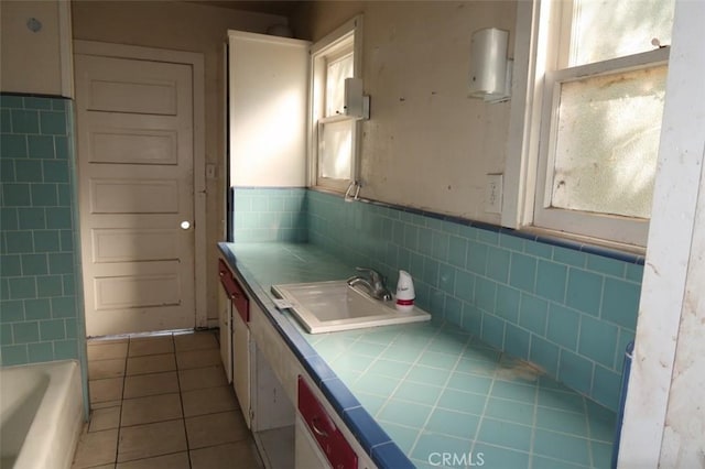 bathroom with tile walls, a washtub, tile patterned flooring, and vanity