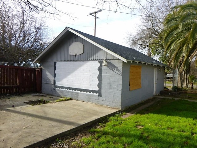 view of property exterior with a patio area and a lawn