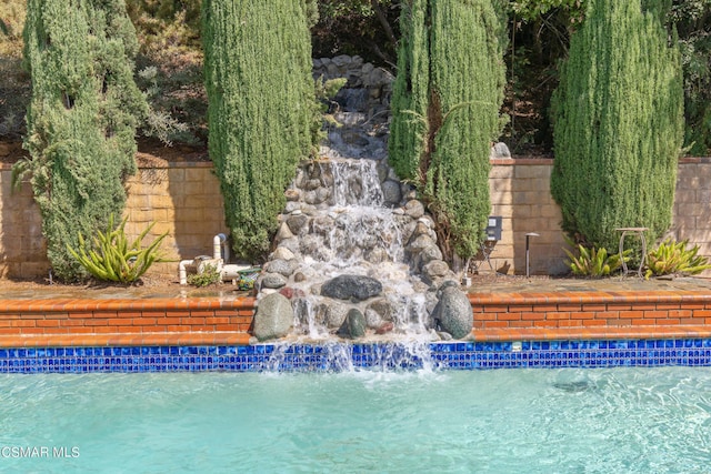 view of pool with pool water feature