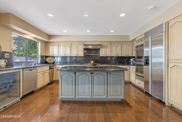 kitchen with beverage cooler, wall chimney range hood, dark hardwood / wood-style floors, decorative backsplash, and appliances with stainless steel finishes