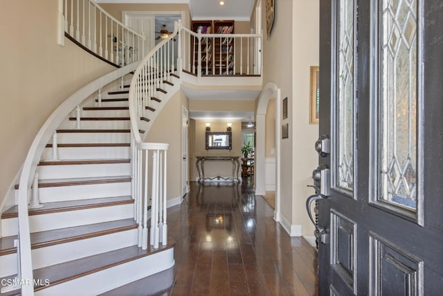 foyer with a high ceiling, dark wood-type flooring, and a healthy amount of sunlight