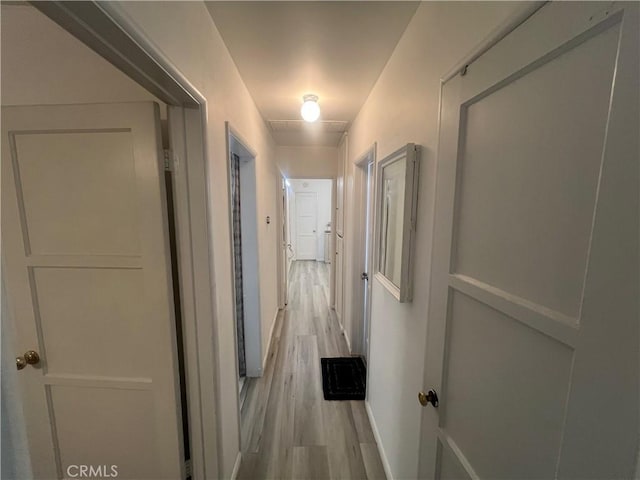 corridor with light hardwood / wood-style floors