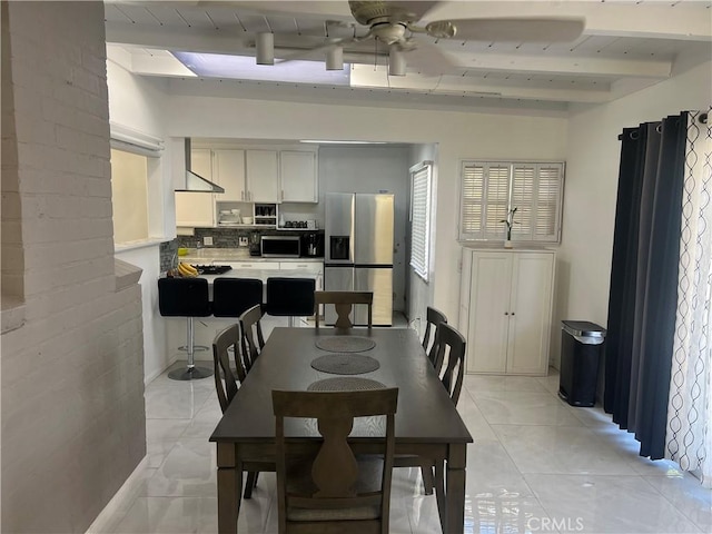 dining space with beam ceiling, light tile patterned floors, and ceiling fan