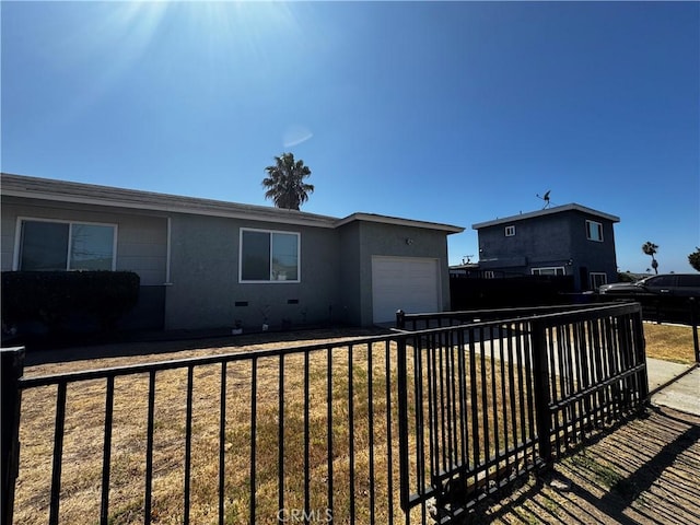 back of house featuring a garage and a lawn