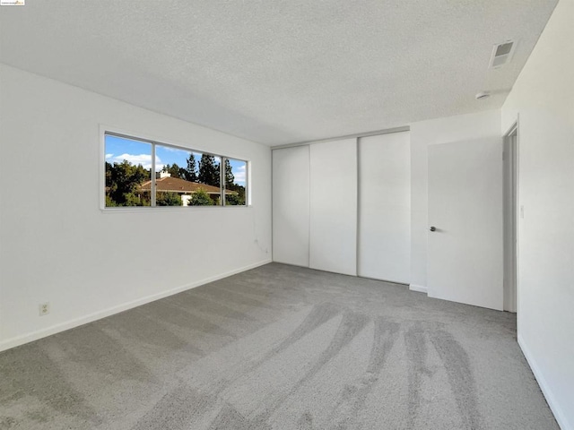 interior space featuring a textured ceiling, a closet, and carpet