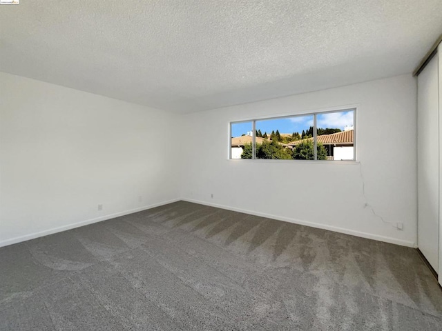 carpeted empty room with a textured ceiling