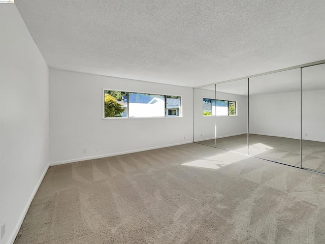 unfurnished bedroom with carpet, a closet, and a textured ceiling