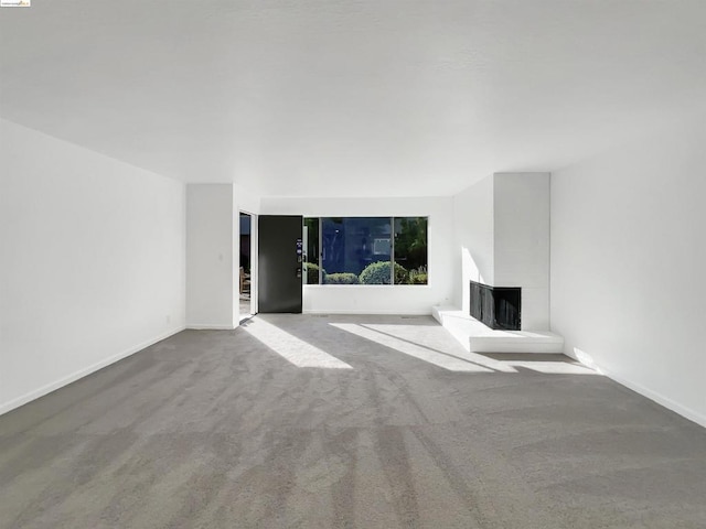 unfurnished living room with a fireplace and carpet flooring