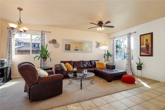 tiled living room with ceiling fan with notable chandelier and a healthy amount of sunlight