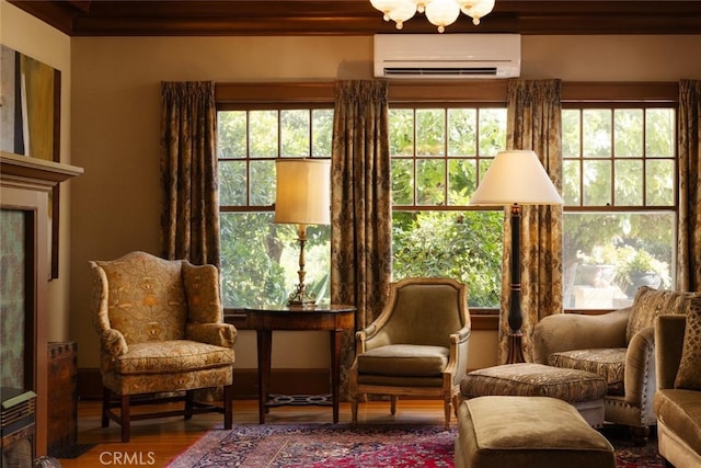 sitting room with an AC wall unit, wood-type flooring, a healthy amount of sunlight, and crown molding