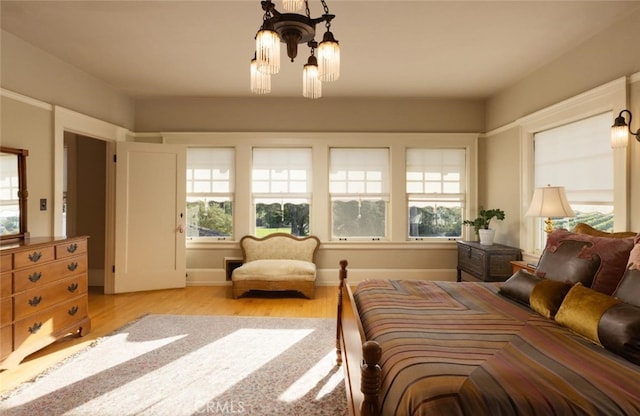 bedroom featuring an inviting chandelier and light hardwood / wood-style floors