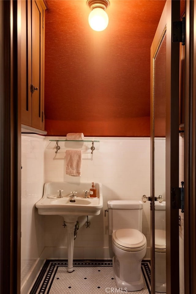 bathroom with toilet and tile patterned floors