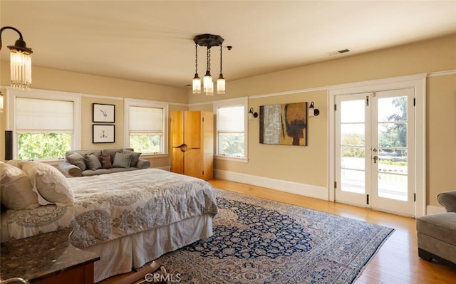 bedroom with wood-type flooring and access to outside