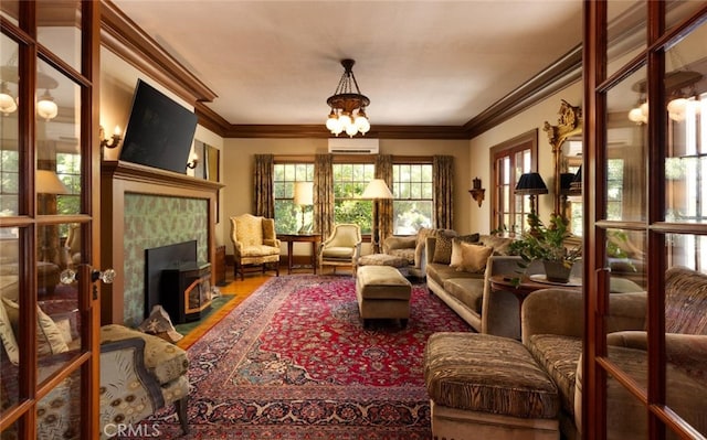 living room with ornamental molding, an inviting chandelier, and a wall mounted air conditioner