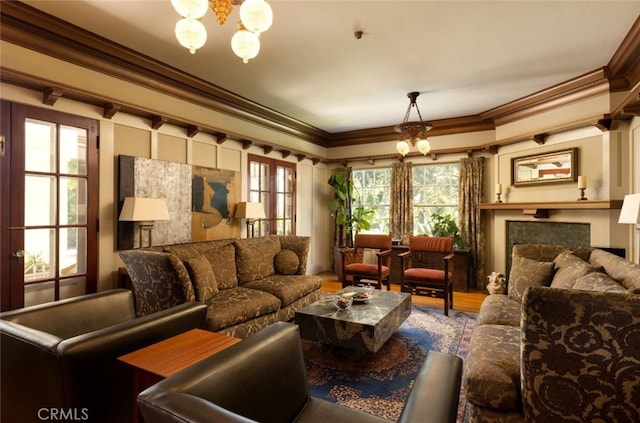 living room with a healthy amount of sunlight, crown molding, and a notable chandelier