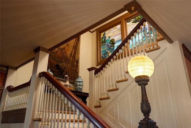 stairway featuring an inviting chandelier and crown molding