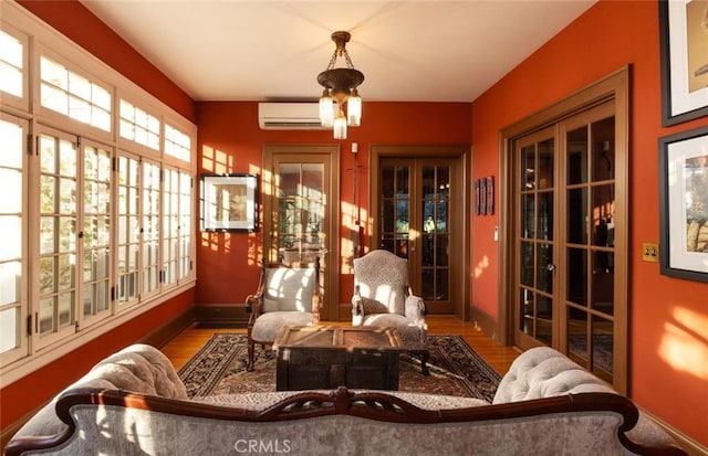 sunroom / solarium featuring an AC wall unit and french doors