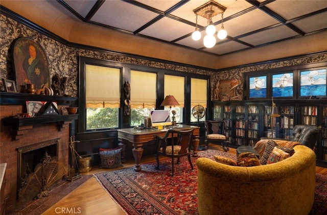 office area featuring a notable chandelier, a brick fireplace, wood-type flooring, and coffered ceiling