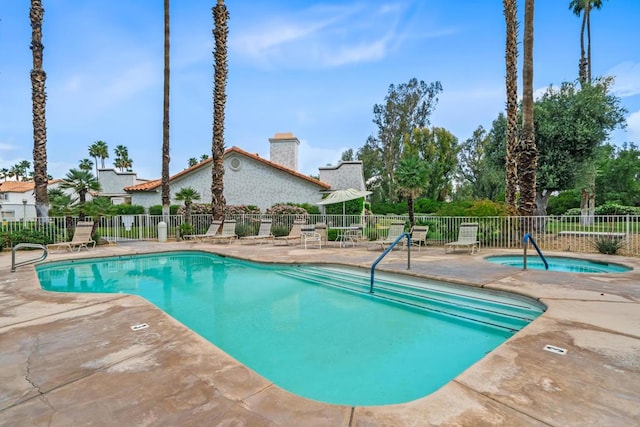 view of pool with a patio area and a hot tub