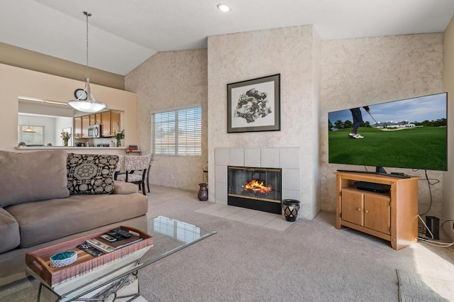 carpeted living room featuring a tile fireplace and high vaulted ceiling