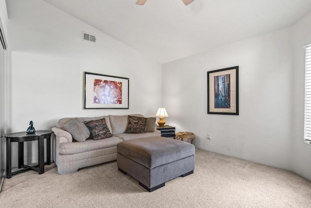 carpeted living room with ceiling fan and lofted ceiling