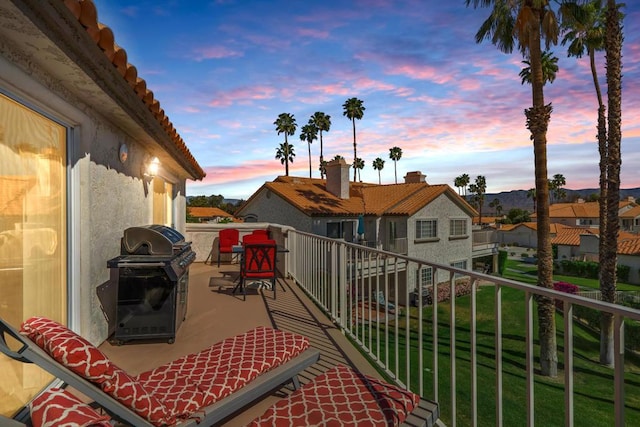 balcony at dusk featuring grilling area