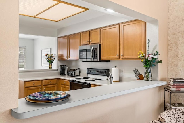 kitchen featuring electric range and kitchen peninsula