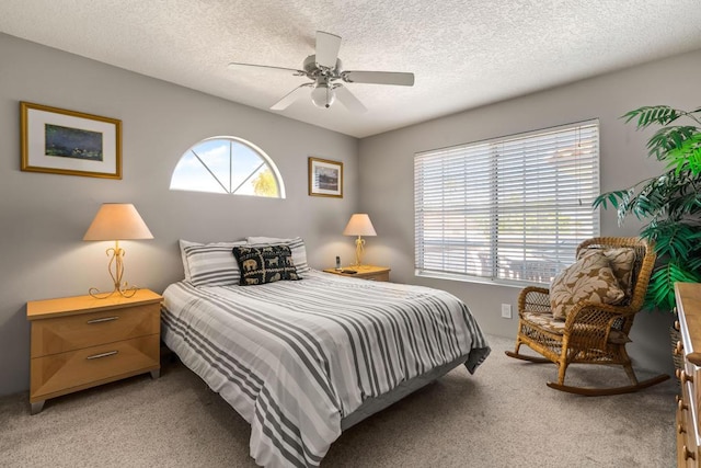 carpeted bedroom with ceiling fan and a textured ceiling