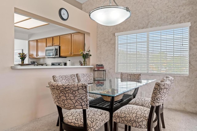 dining area featuring light colored carpet and a wealth of natural light