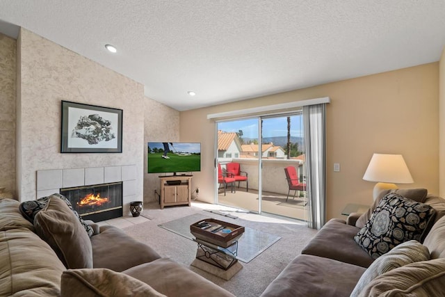 carpeted living room with a tile fireplace and a textured ceiling