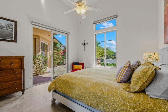 tiled bedroom with multiple windows, ceiling fan, and access to exterior