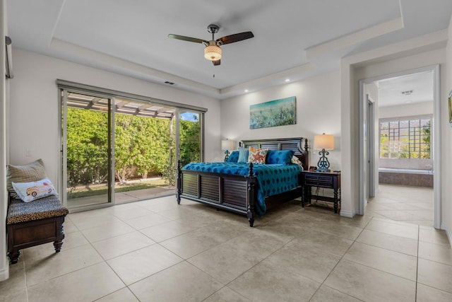 bedroom with ceiling fan, a raised ceiling, light tile patterned floors, ensuite bathroom, and access to exterior