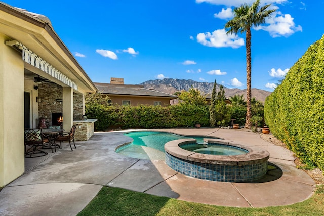 view of pool with a mountain view, an in ground hot tub, and a patio area