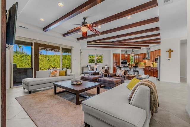 tiled living room featuring ceiling fan, sink, and beam ceiling