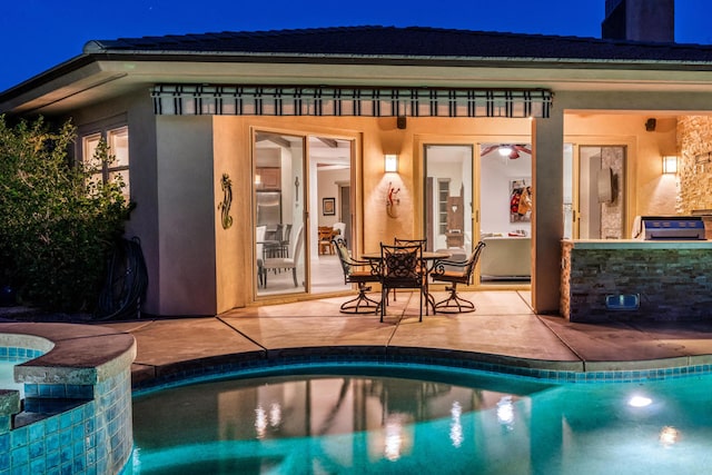 pool at twilight featuring french doors, a patio area, and exterior kitchen