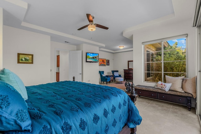 bedroom with a tray ceiling and ceiling fan