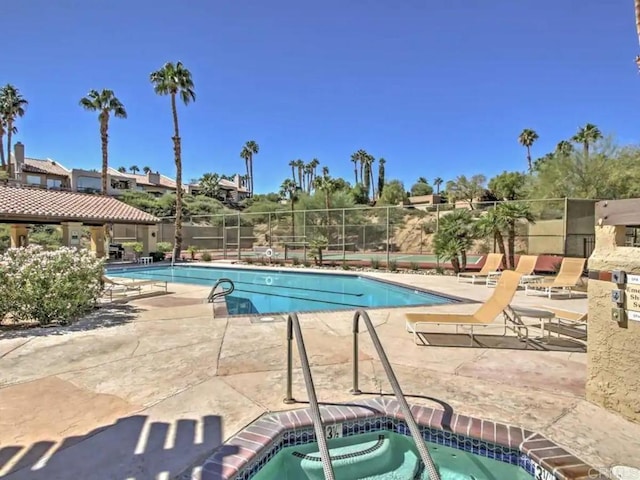 view of swimming pool with a patio and a community hot tub